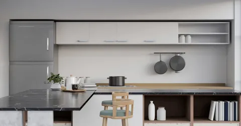 A modern kitchen with white cabinets, a grey refrigerator, and a black marble island showcasing the best countertop material for style, durability, and everyday functionality.